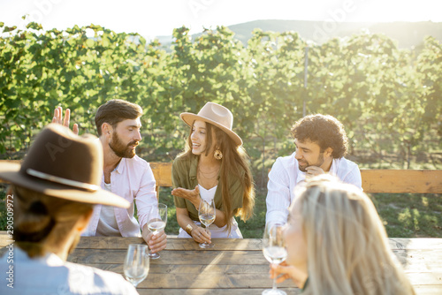 Photography Group of a young people drinking wine and having fun together while sitting at t