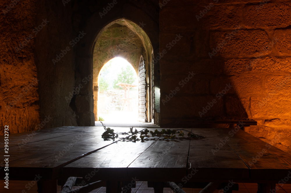 wooden table in dark chamber with light coming from outside