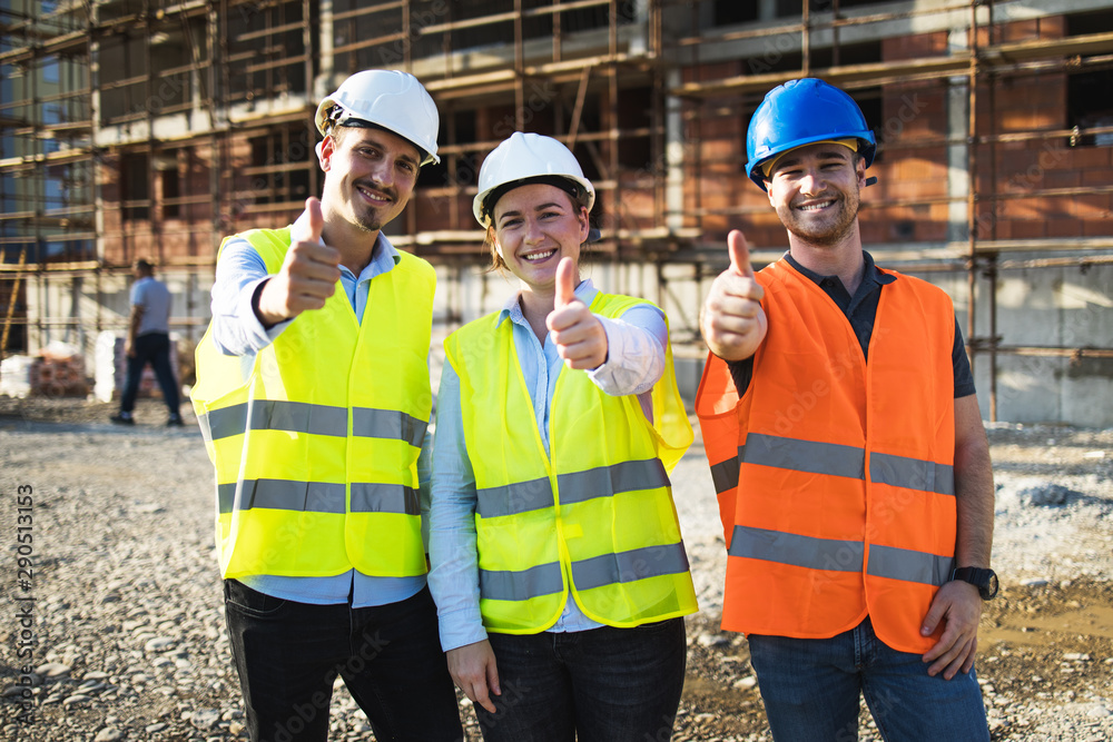 Three construction workers having meeting,pose for the photographer,stock photo - obrazy, fototapety, plakaty 