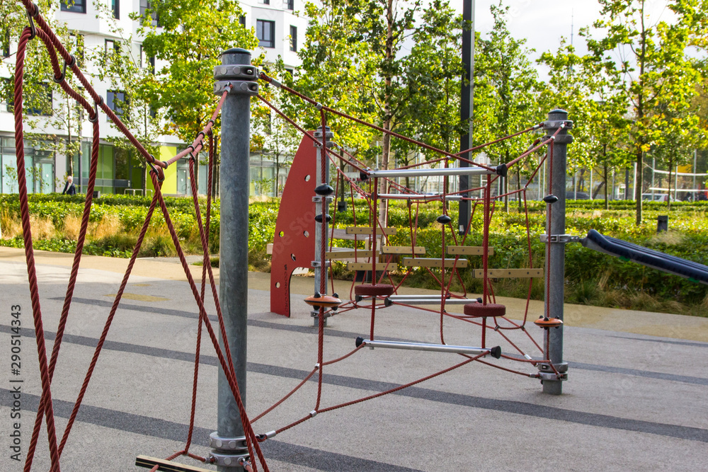 Modern playground with a piece of rope equipment inscribed in the landscape design. Climbing net at the park playground Modern playground with a piece of rope equipment inscribed in the landscape design. Climbing net at the park playground