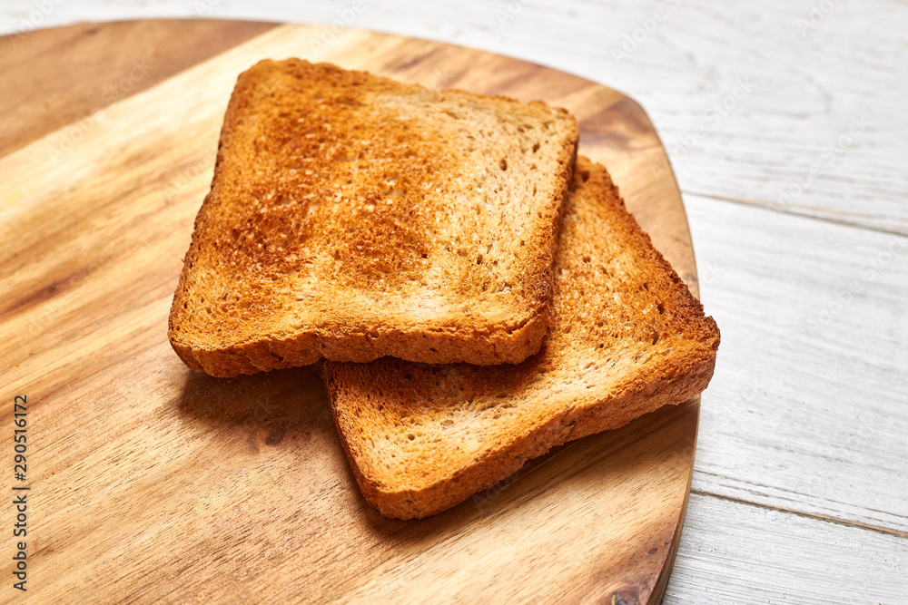 Toasted white bread toasts on a wooden background. Toasted white bread toasts on a wooden background.