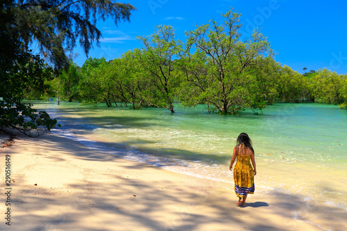 Woman walking along tropical beach