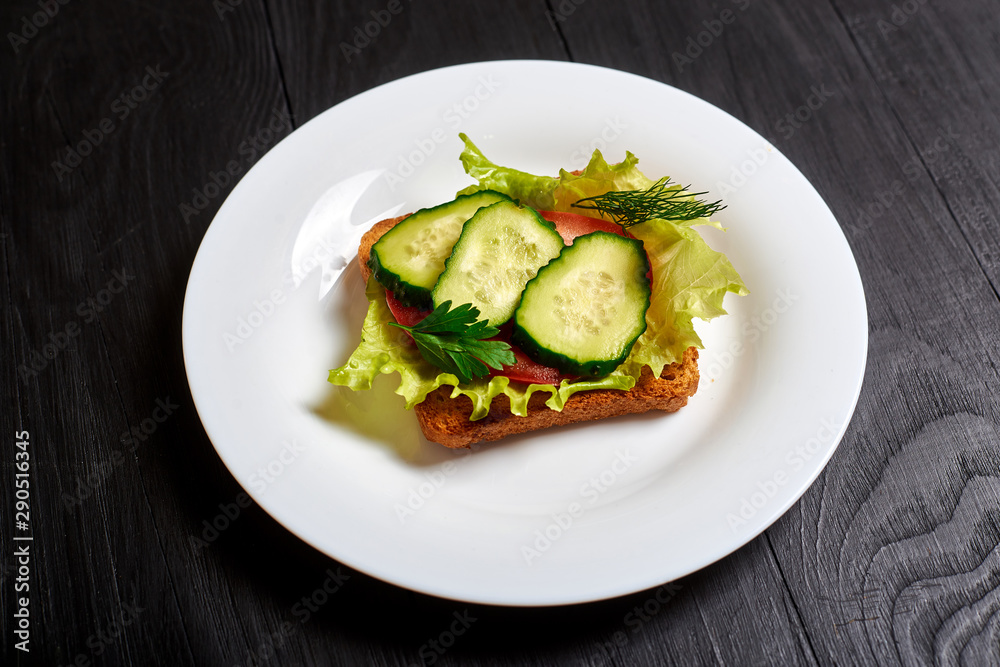 Sandwich with fresh vegetables, vegetarian. Salad, cucumbers, tomato on toasted toast.