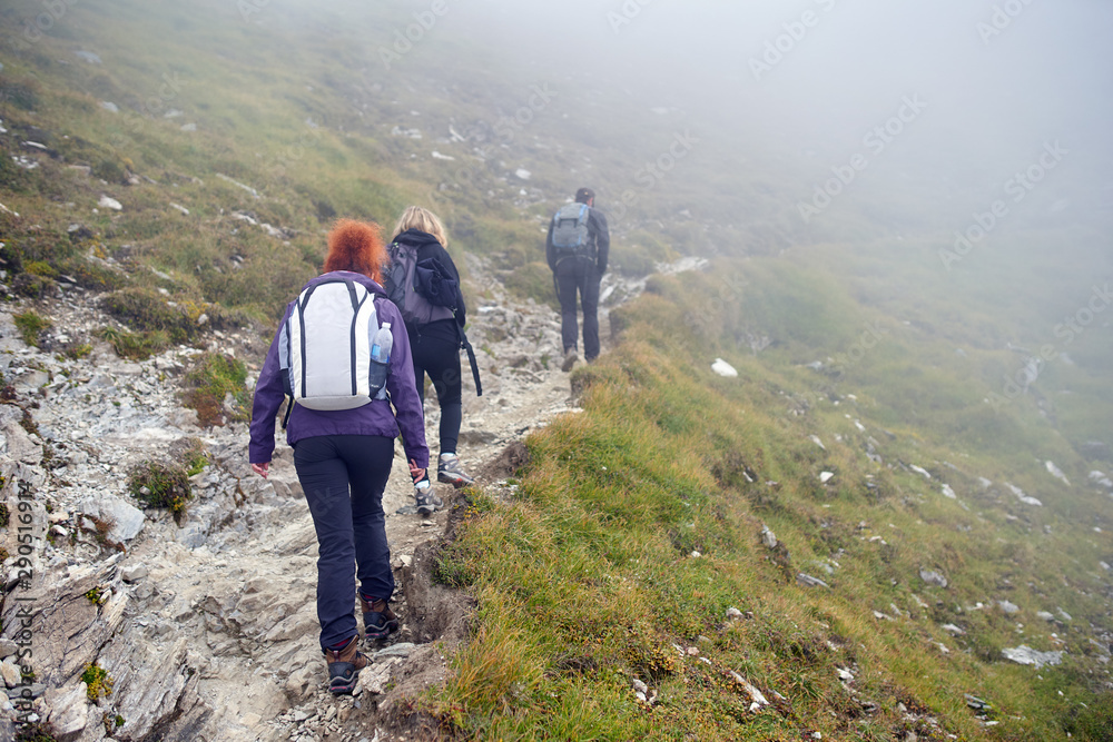 People with backpacks hiking into the mountains