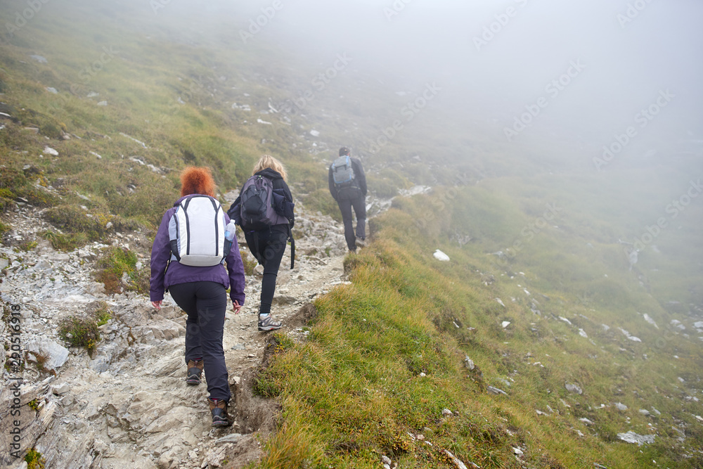 People with backpacks hiking into the mountains