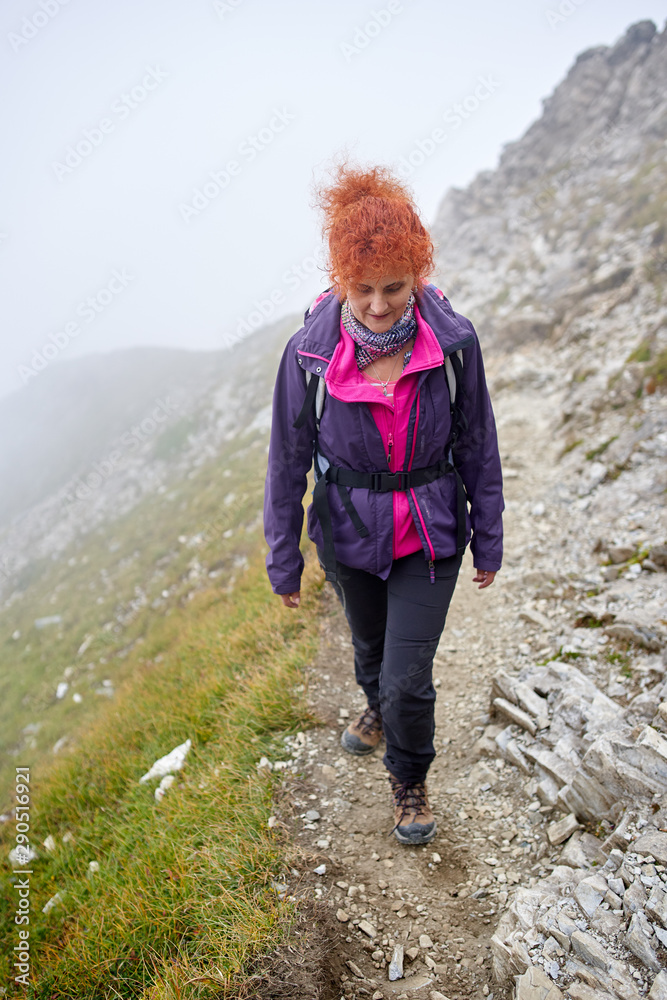 Backpacker lady hiking on a trail
