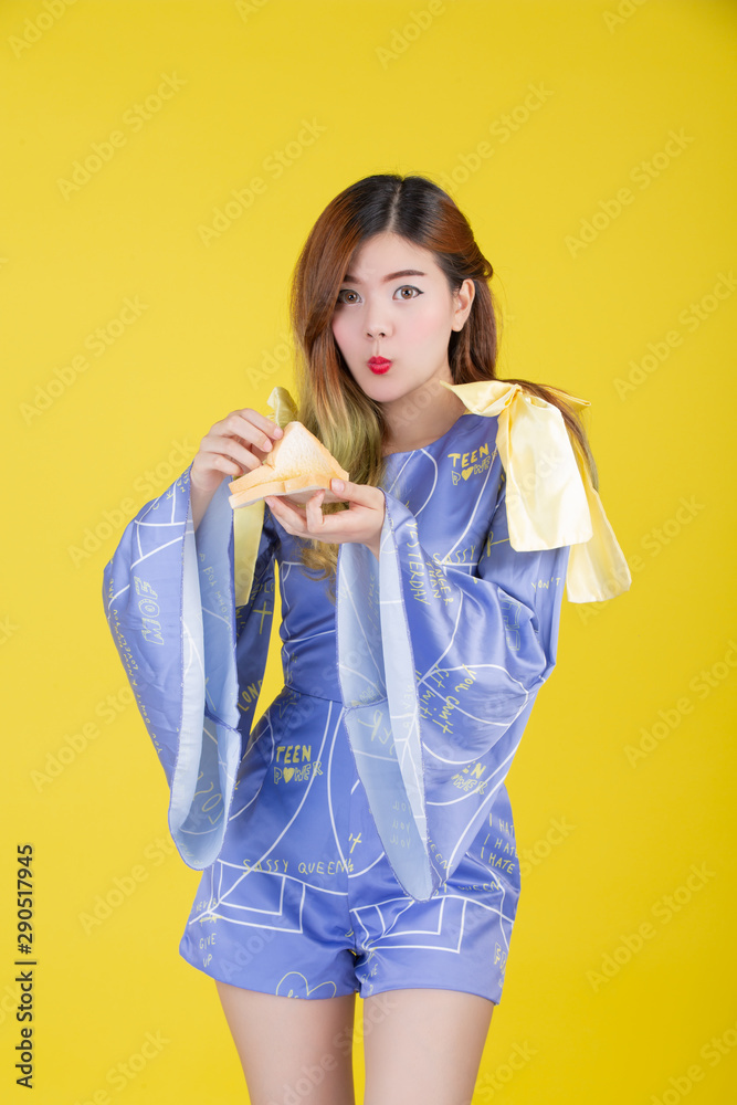 Fashion girl dress up with a hand gesture, eat milk on a yellow background. Fashion girl dress up with a hand gesture, eat milk on a yellow background.
