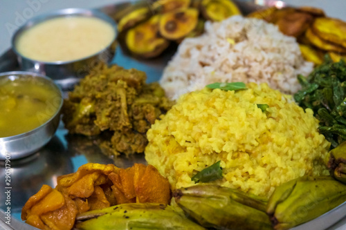 Indian Festve Foods. Traditional Bengali dishes for Indian Hindu Durga Puja or pooja festive food. A plate full of khichdi, pulao, curry, payesh and some fries.