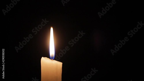 Wind blow out candle flame flickering on black background