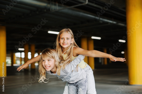 Two beautiful girls having fun and playing in the parking lot. Street photo shoot