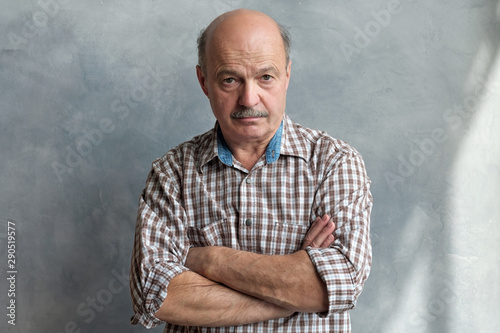 Bild auf Leinwand Middle aged hispanic man with doubtful expression and arms crossed looking at camera