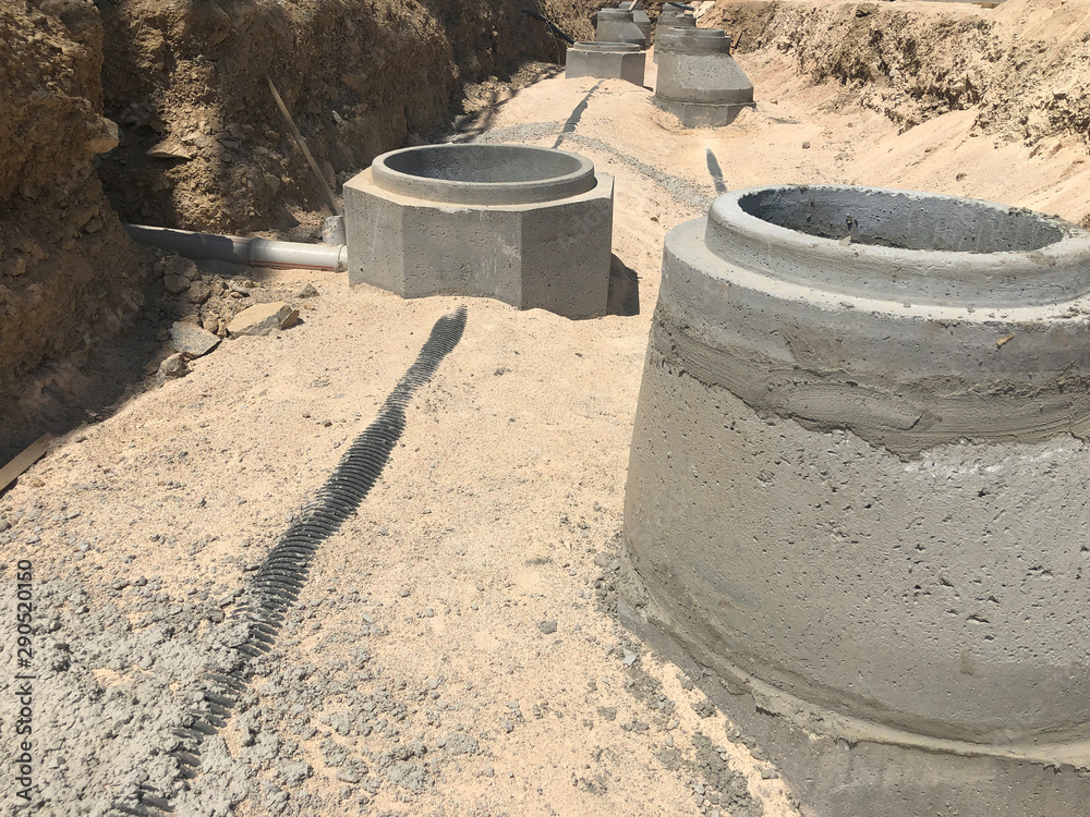 Storm water drainage reinforced concrete wells in the dug trench. Water drainage system under construction