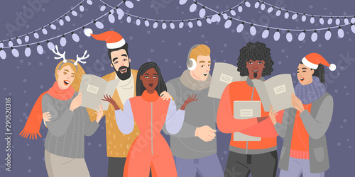 A group of young people in warm clothes and Santa Claus hats sing Christmas songs in the evening