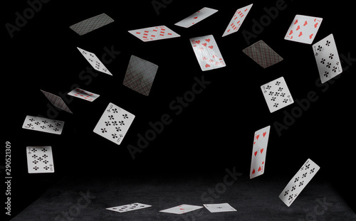playing cards fall on a black table photo