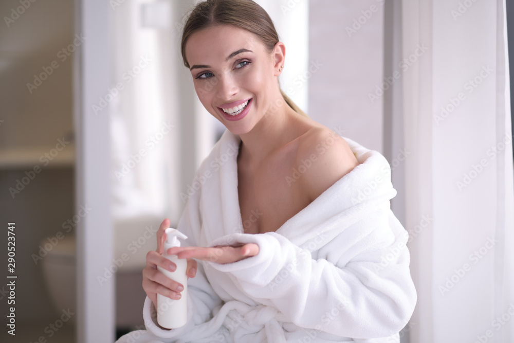 Portrait of pretty young woman applying body cream on skin Portrait of pretty young woman applying body cream on skin