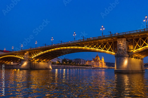 The Margaret Bridge with Parliament Building on background in Budapest, Hungary, illuminated above the Danube river at night. © Viliam