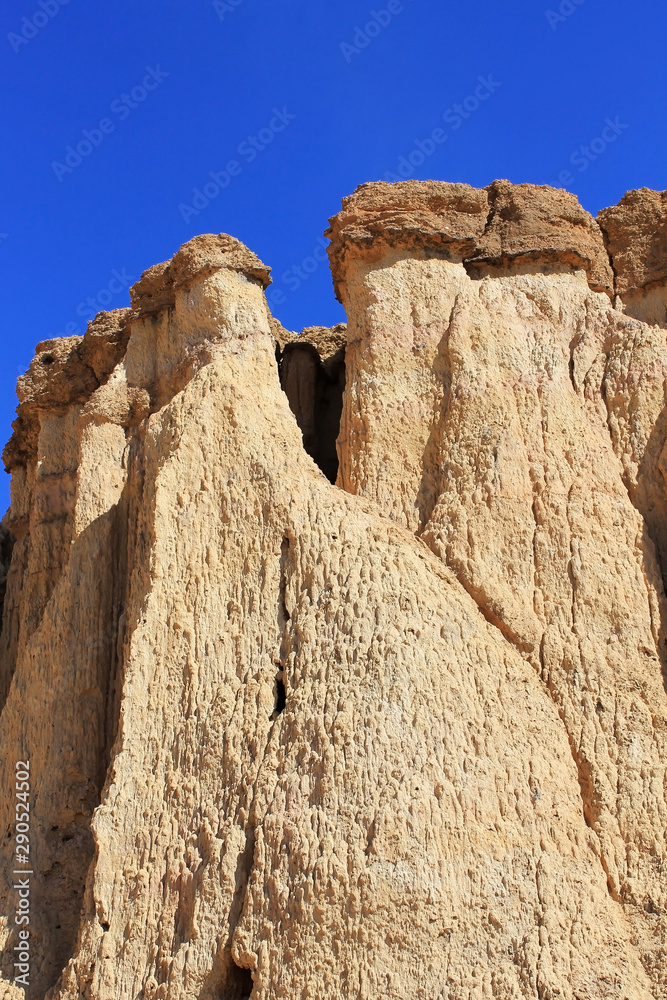 Details of the beautifully coloured cliffs of Tsagaan Suvraga « white stupa » in the Gobi desert on a bright sunny day, Dundgovi Province, Mongolia. Vertical view.