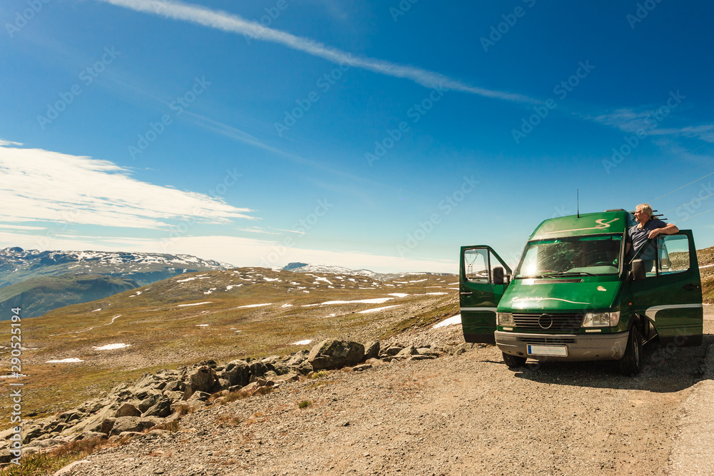 Male tourist enjoy mountains landscape from camper van.