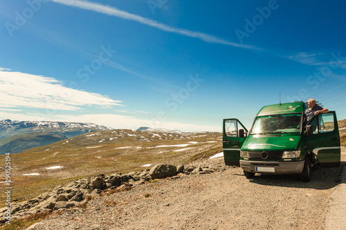 Male tourist enjoy mountains landscape from camper van.