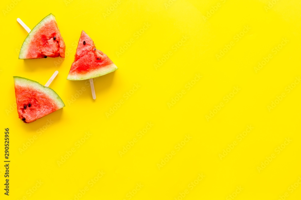 Slices of watermelon popsicle on yellow background top view mock up Slices of watermelon popsicle on yellow background top view mock up