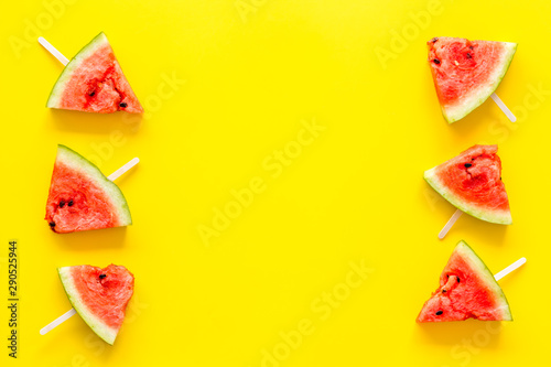 Slices of watermelon popsicle on yellow background top view mock up