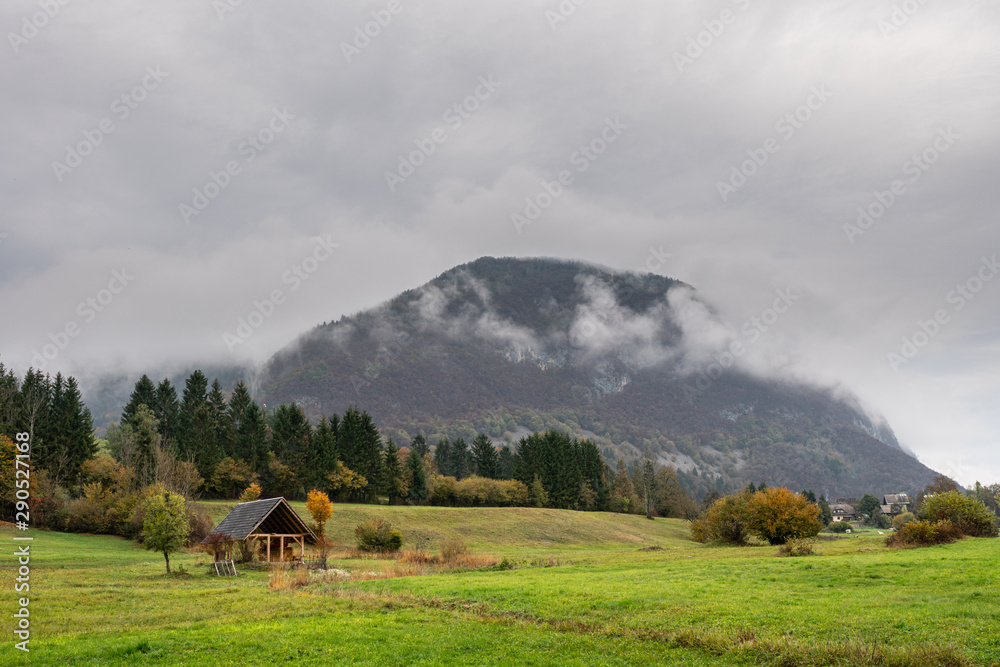 Amazing alone cabin in misty valley Cloudy sky in mountains Inspirational  background  foggy landscape in autumn.