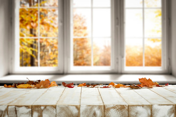 White wooden table and autumn leaves 
