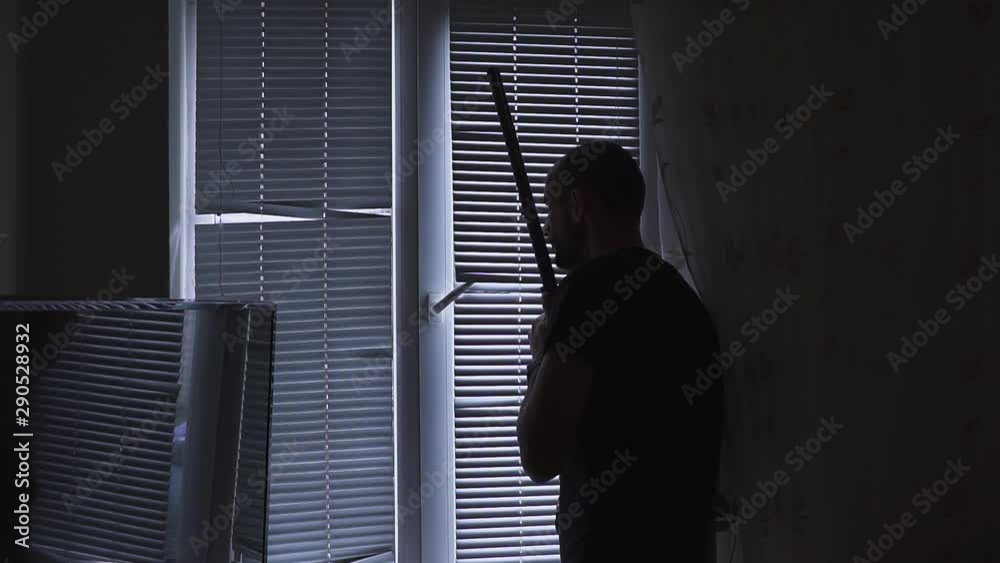 man with gun, looking through the window. bodyguard and self defense concept, otherwise robber, murderer and thief concept man with gun, looking through the window. bodyguard and self defense concept, otherwise robber, murderer and thief concept