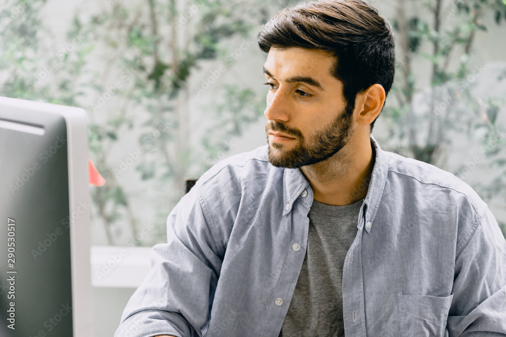 caucasian working man with beard and mustache in casual shirt using desktop computer caucasian working man with beard and mustache in casual shirt using desktop computer