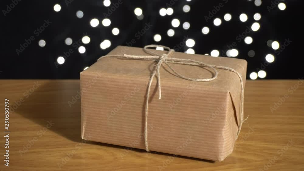 Caja de regalo en la mesa y fondo negro con luces