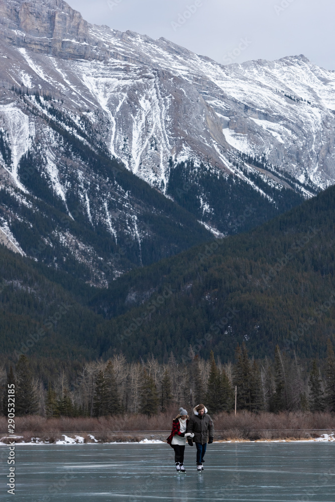 Couple skating together in snowy landscape Couple skating together in snowy landscape