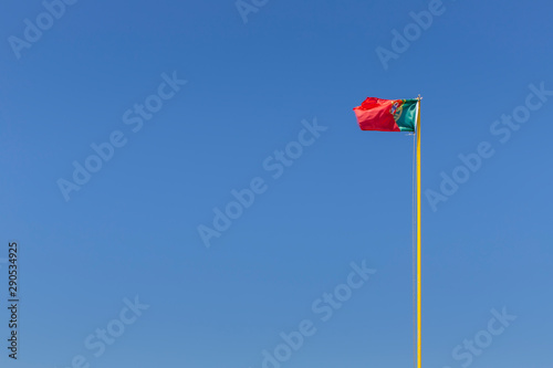 Portuguese flag photographed against a blue sky