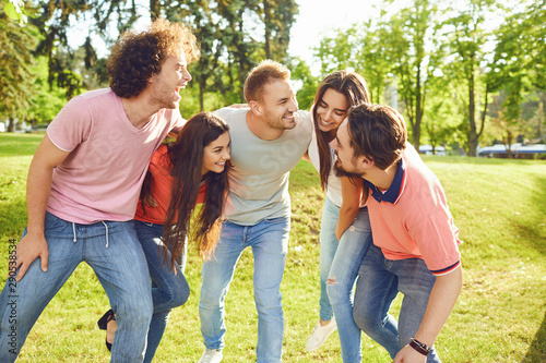 A group of friends laughing hugging in a park
