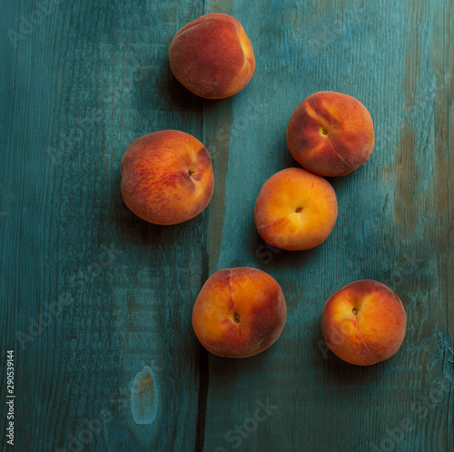 Fresh ripe peaches fruits on wooden rustic background. Top view.