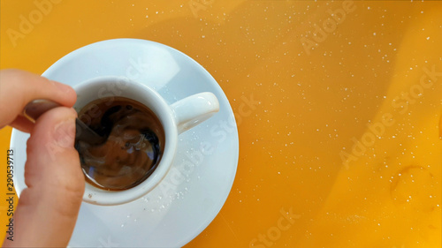 Top view of hand stirring sugar in coffee photo