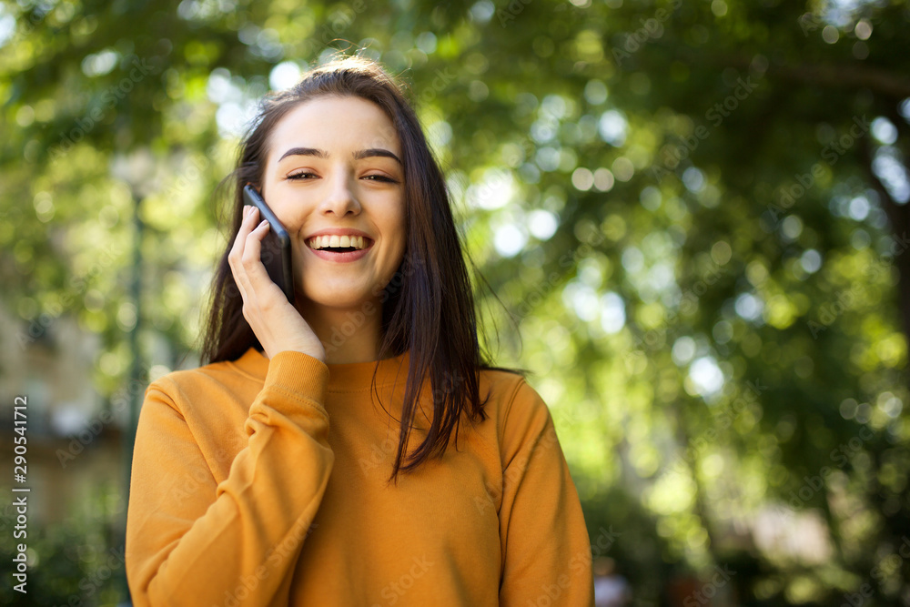 smiling young woman talking with cellphone fin park smiling young woman talking with cellphone fin park