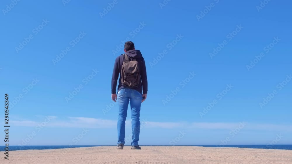 Young man tourist travel blogger shooting video on smartphone at sea pier, low angle view. Guy blogger works creates content on phone for social media, modern job. Travel journey trip sunny day. Young man tourist travel blogger shooting video on smartphone at sea pier, low angle view. Guy blogger works creates content on phone for social media, modern job. Travel journey trip sunny day.