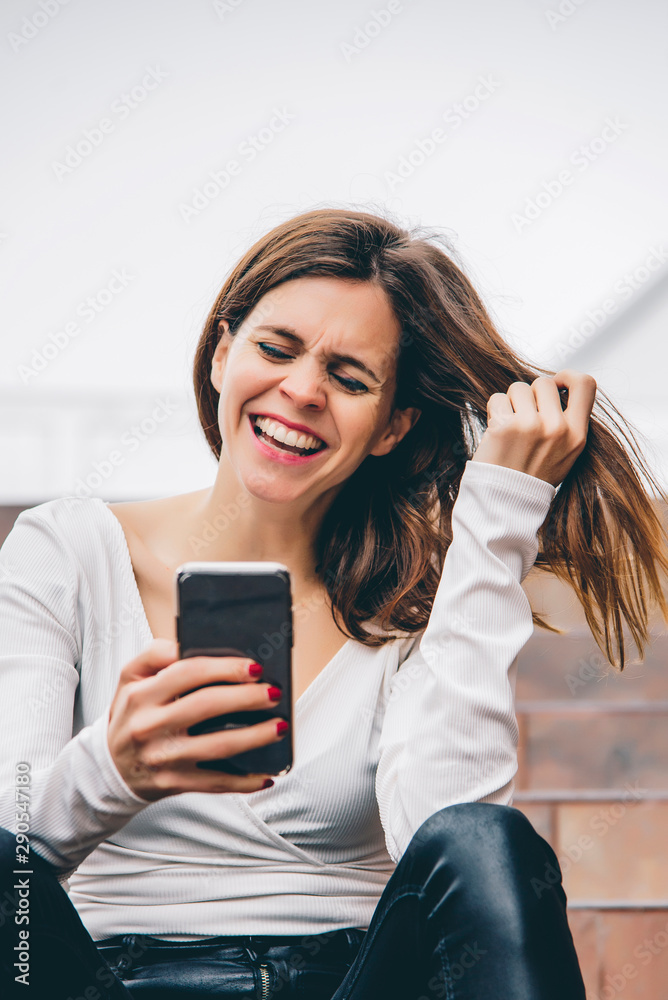 Portrait of a beautiful woman smiling looking at her phone Portrait of a beautiful woman smiling looking at her phone