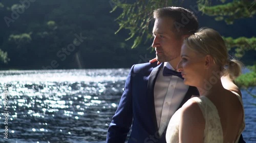 Bride and Groom During the Weeding Day Outdoor in the Middle of the Nature Beside the Lake Slow Motion photo