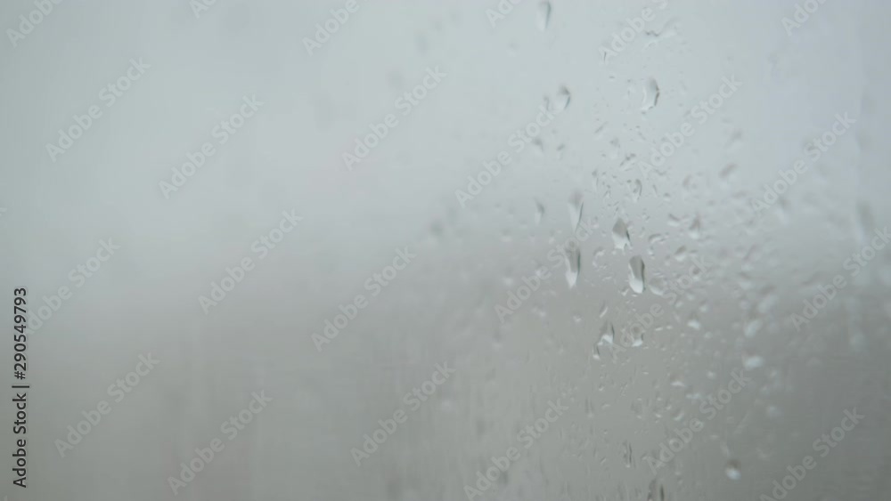 Raindrops on wet glass. Wet window against a gray rainy sky. Raindrops on wet glass. Wet window against a gray rainy sky.