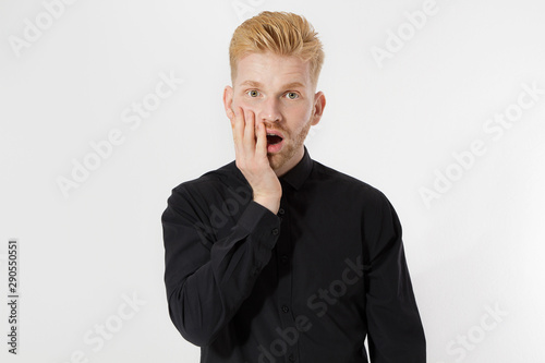 Excited surprised shock young man isolated on gray background. Happy Redhead guy with red beard in black stylish shirt. Success and pass exam concept. Copy space. Close up of Face expression.