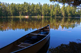 Lake and canoe after portage in sunny pine forest in Algonquin Park..
