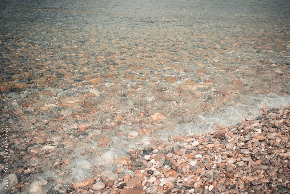 Sea pebbles and stones underwater. Textural seabed through clear transparent blue water. Natural background. Sea pebbles and stones underwater. Textural seabed through clear transparent blue water. Natural background.