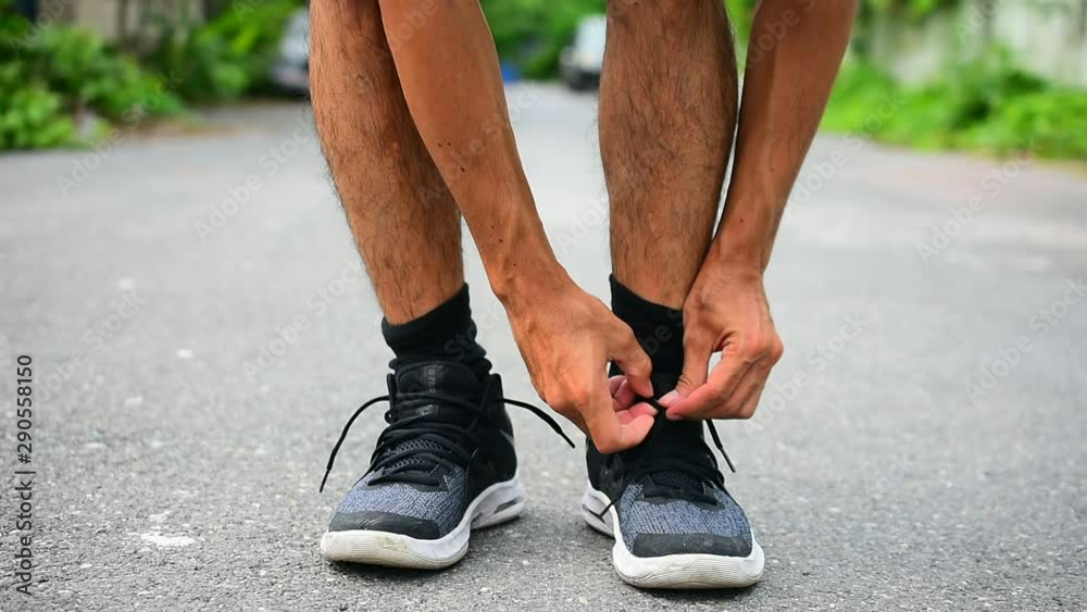 Runners tied in shoes,Man run on the street be running for exercise,Run sports background and closeup at running shoe Runners tied in shoes,Man run on the street be running for exercise,Run sports background and closeup at running shoe