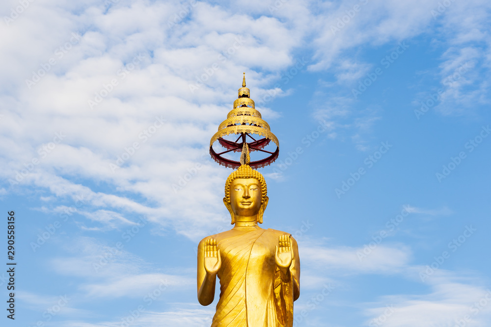 Sculpture Golden Buddha Statue standing isolated with Clearly Blue Sky Background