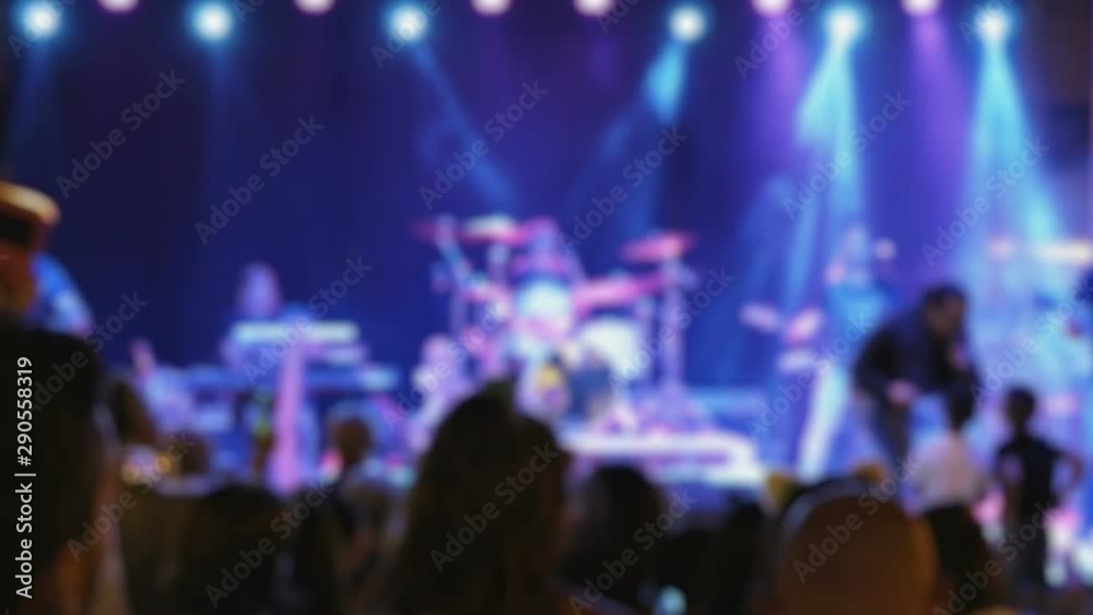 Silhouette of people dancing at a night party concert. Young people raised their hands on bright stage lights. Handheld blurred footage in slow-motion. Silhouette of people dancing at a night party concert. Young people raised their hands on bright stage lights. Handheld blurred footage in slow-motion.