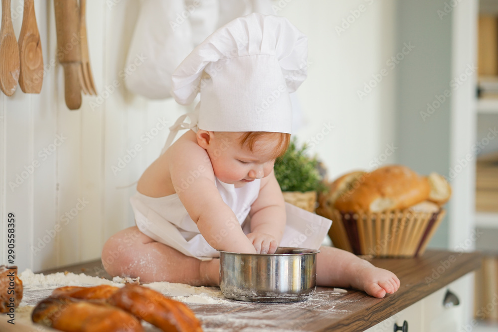 little baker child in chef hat at kitchen table alone little baker child in chef hat at kitchen table alone