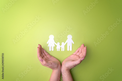 Female tender hands with a family symbol cut out of white paper. Protecting the rights of people and sexual minorities. Love for the children of the world on earth, a clean ecology. View from above.