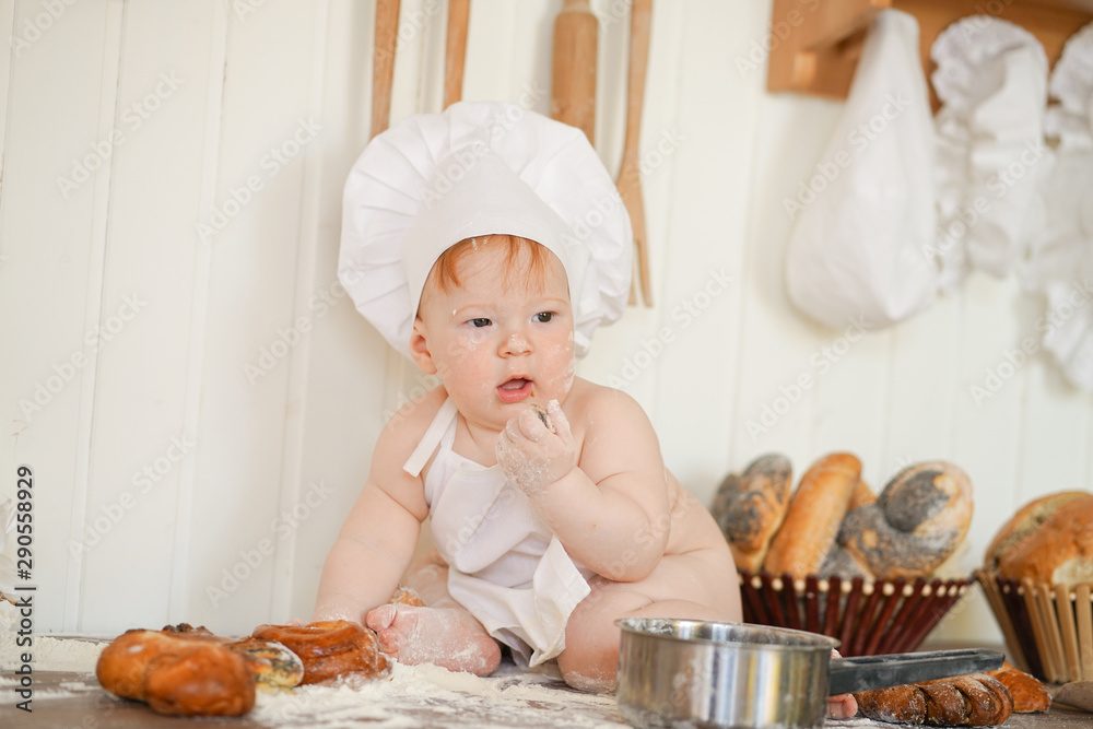little baker child in chef hat at kitchen table alone little baker child in chef hat at kitchen table alone
