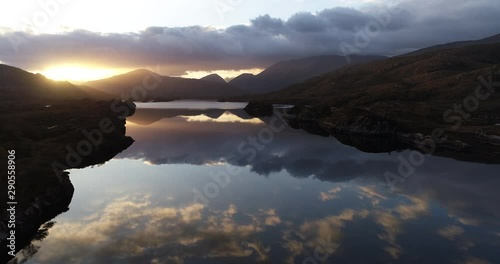 Sunset over lake in Irish countryside, wide aerial